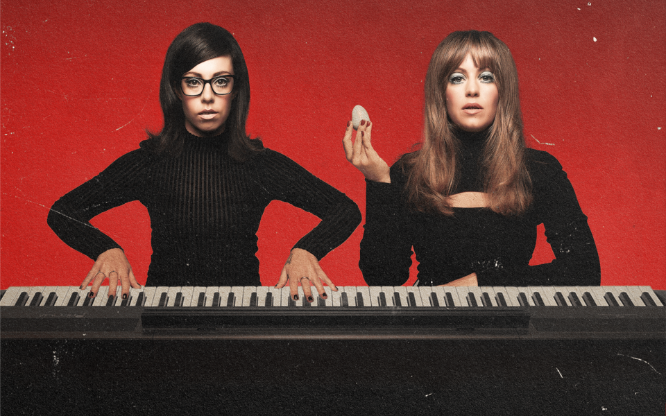 Flo And Joan Flo And Joan sat behind a large piano wearing all black