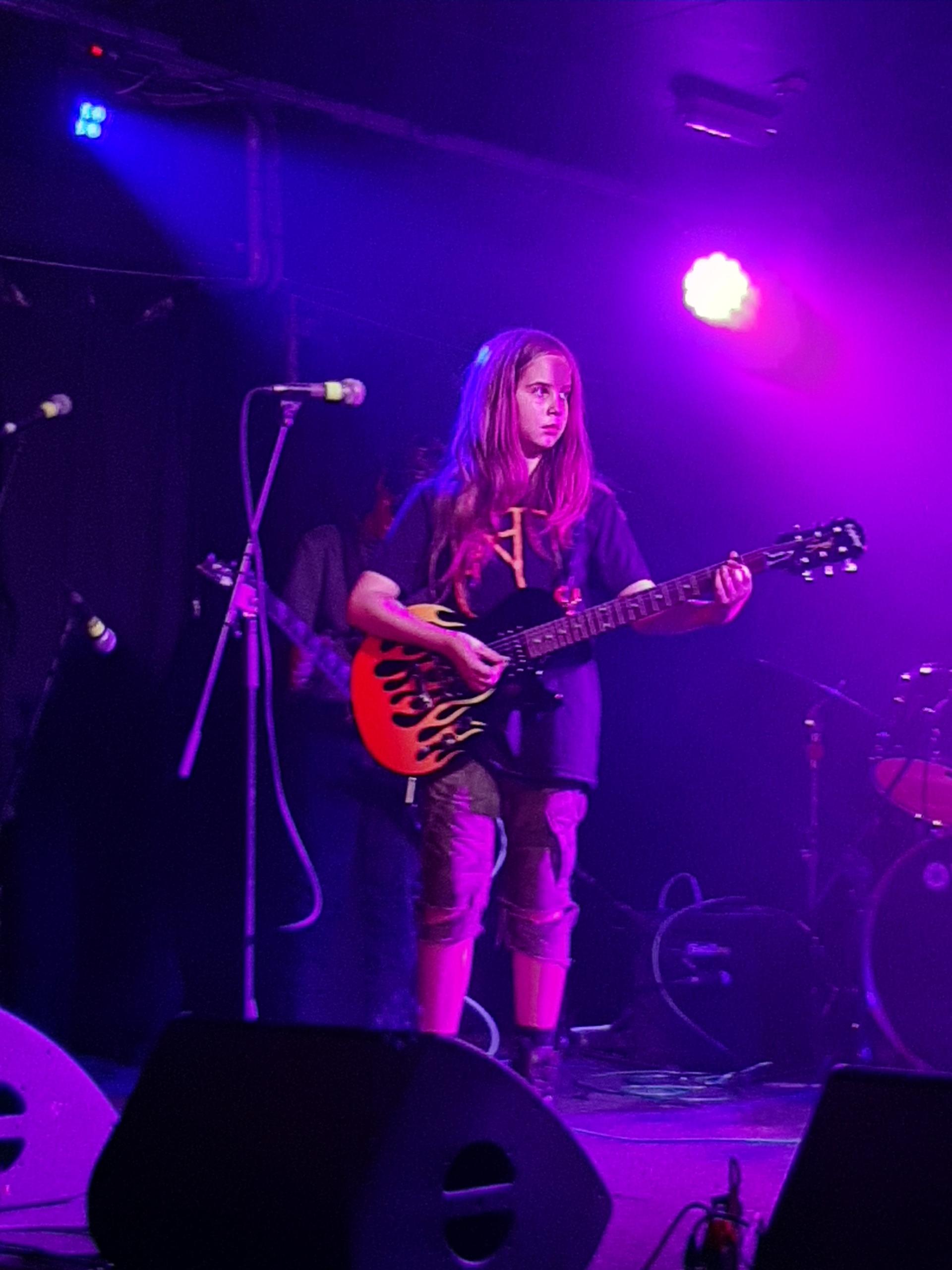 Rook playing guitar A boy with long hair playing electric guitar on stage