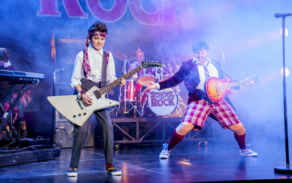 School of Rock A boy playing guitar alongside Jake Sharp playing Dewey Finn